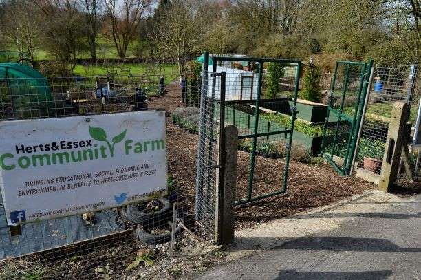 view of Herts and Essex Community farm from outside the gate showing a sign on the fence